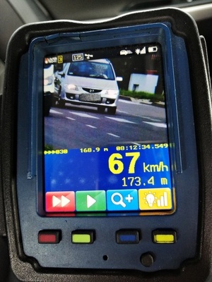 Zdjęcie ekranu miernika prędkości, w okienku ulica, jadące samochody, prędkość pojazdu