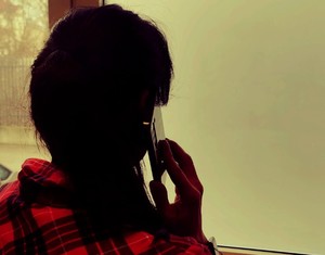 Kobieta stojąca tyłem rozmawiająca przez telefon